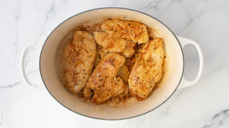 Seared chicken breasts in a large Dutch oven