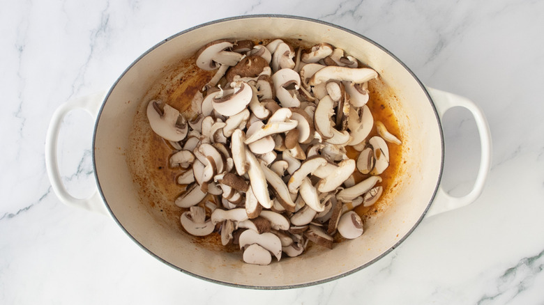 Raw sliced mushrooms in a large Dutch oven