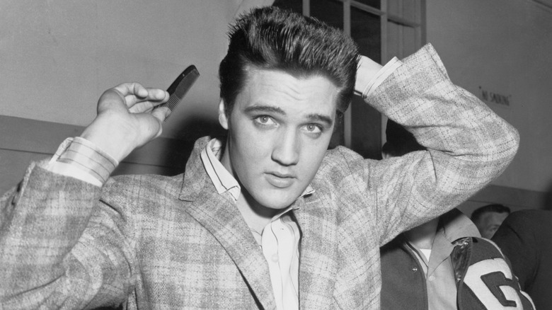 Elvis presley holding a hair comb