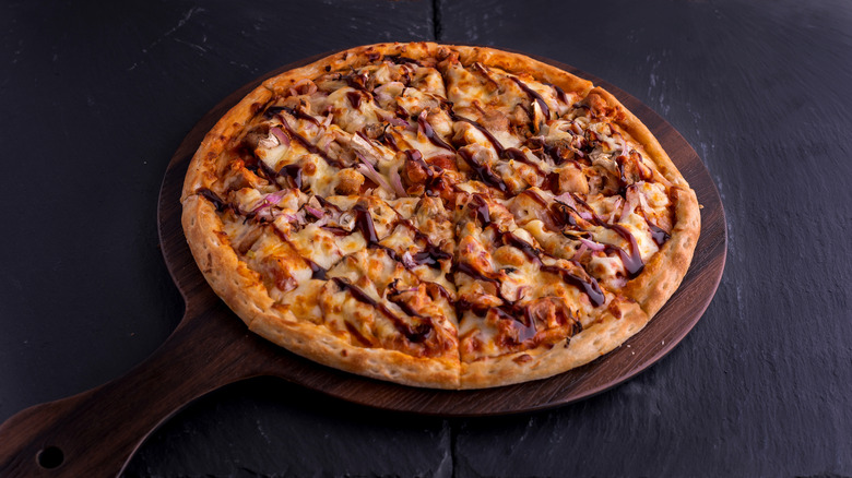A barbecue chicken pizza resting on a counter.