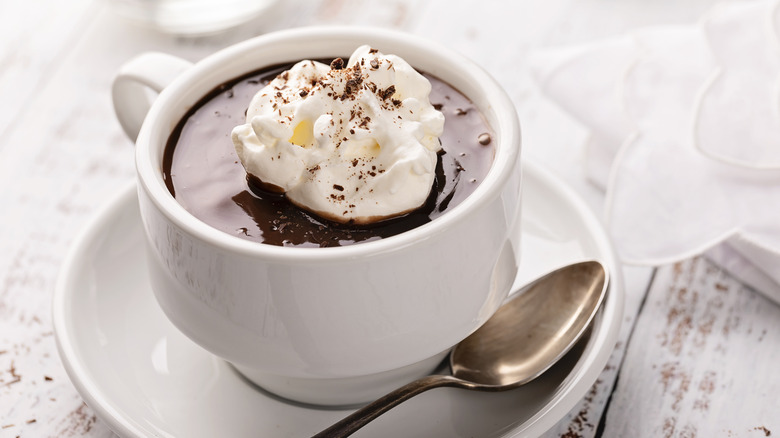 Hot chocolate with whipped cream and spoon.