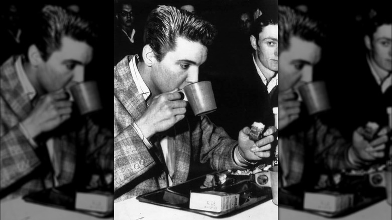 Elvis drinking from the handle side of a mug