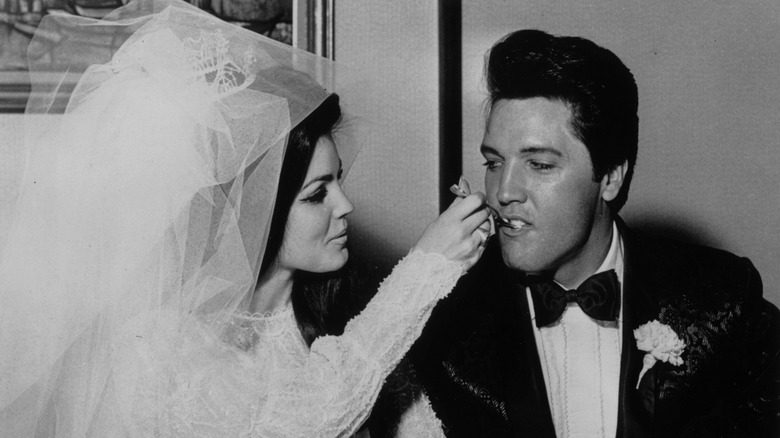 Priscilla Presley feeding wedding cake to Elvis Presley