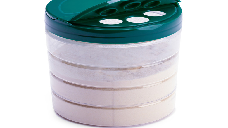 Open package of Parmesan cheese cut out on white background