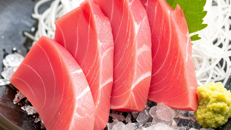 Four slices of raw sashimi on a plate