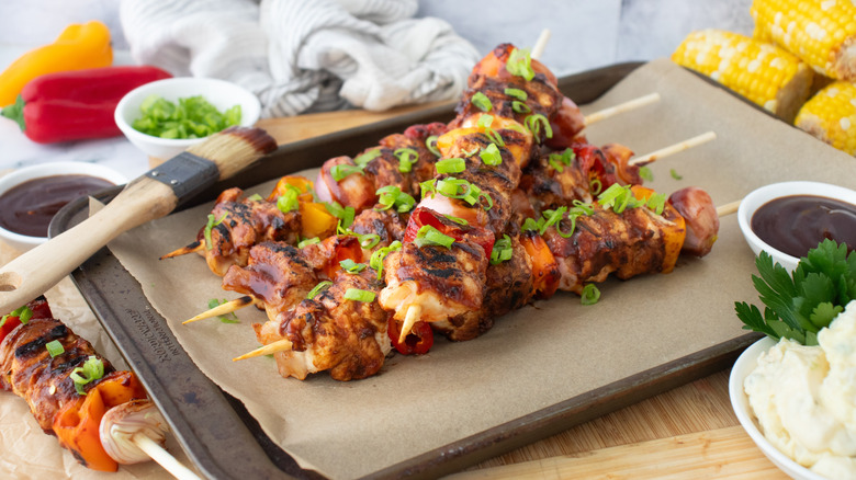 Side shot of grilled chicken skewers with barbecue sauce