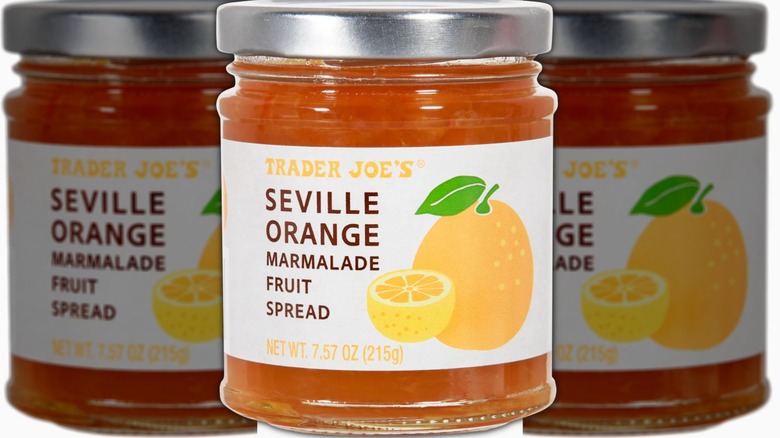 Glass jar of Seville Orange Marmalade Fruit Spread with a white label, brown lettering, and drawing of yellow lemon with green stem and leaf