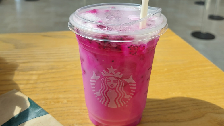 Starbucks dragonfruit refresher on top of wooden table.