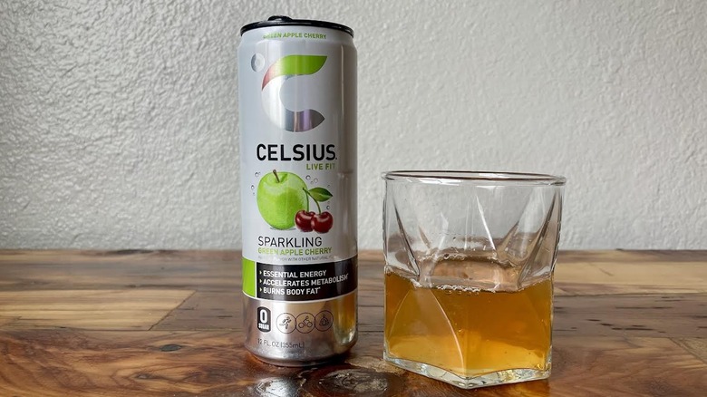 Can and glass of Sparkling Green Apple Cherry Celsius on a wooden tabletop