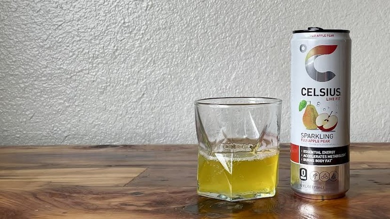 Can and glass of Sparkling Fuji Apple Pear Celsius on a wooden tabletop