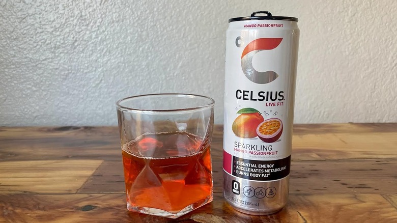 Can and glass of Sparkling Mango Passionfruit Celsius on a wooden tabletop