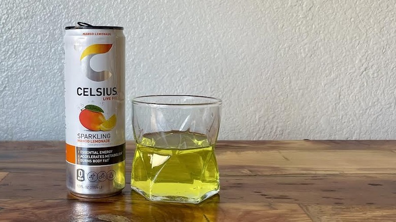 Can and glass of Sparkling Mango Lemonade Celsius on a wooden tabletop