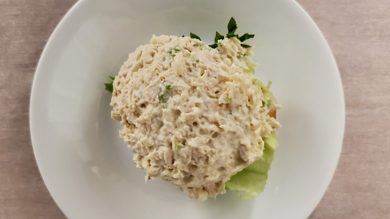 Classic Carol chicken salad from Chicken Salad Chick on a single leaf of lettuce and a small, white plate