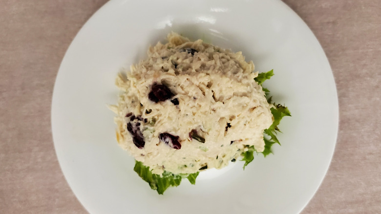 Cranberry Kelli chicken salad from Chicken Salad Chick on a lettuce leaf on a small, white plate
