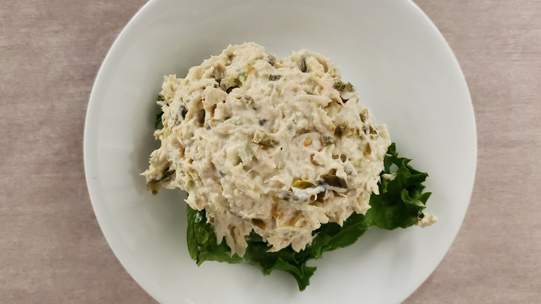 Jalapeño Holly chicken salad from Chicken Salad Chick on a lettuce leaf on a small, white plate