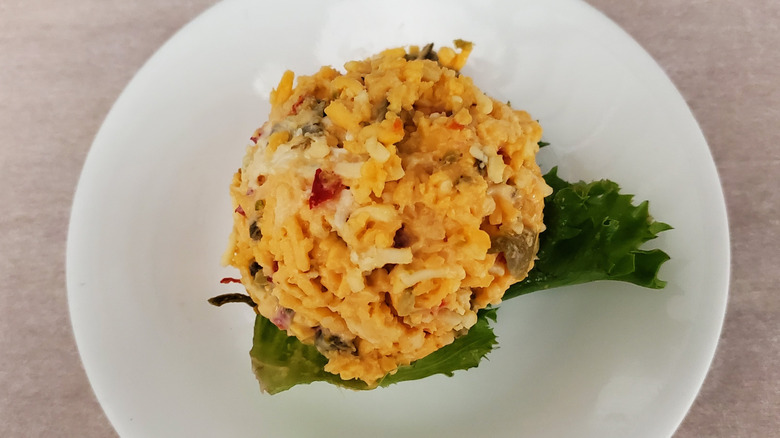 Jalapeño Pimento Cheese chicken salad from Chicken Salad Chick on a lettuce leaf on a small, white plate