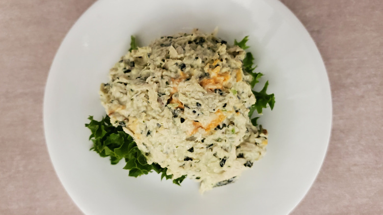 Lauryn's Lemon Basil chicken salad from Chicken Salad Chick on a lettuce leaf on a small, white plate