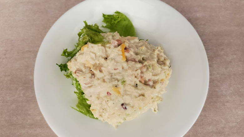 Sassy Scotty chicken salad from Chicken Salad Chick on a lettuce leaf on a small, white plate