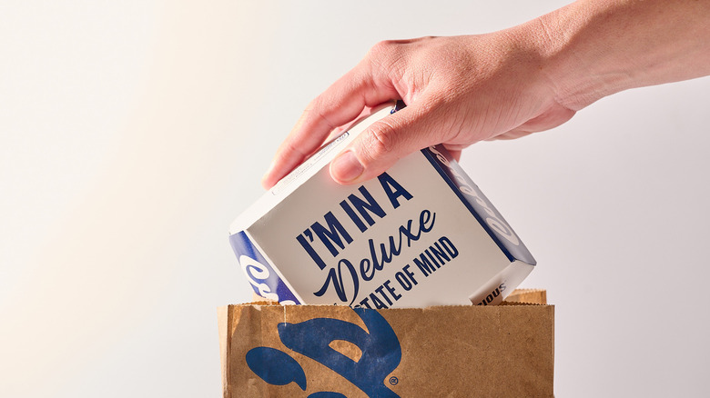 Hand grabbing burger box out of paper bag