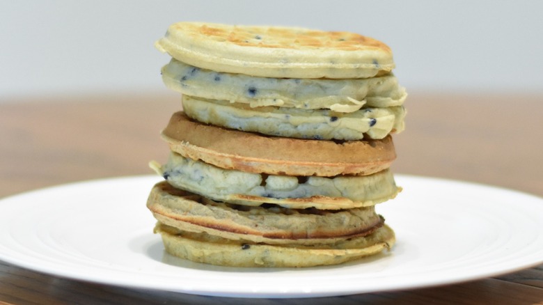 A stack of blueberry waffles on a white plate