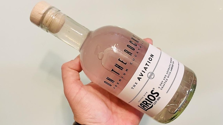 Hand holding bottle of On The Rocks Aviation