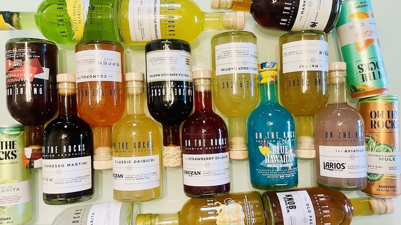 Collection of On The Rocks bottles and cans lying on table