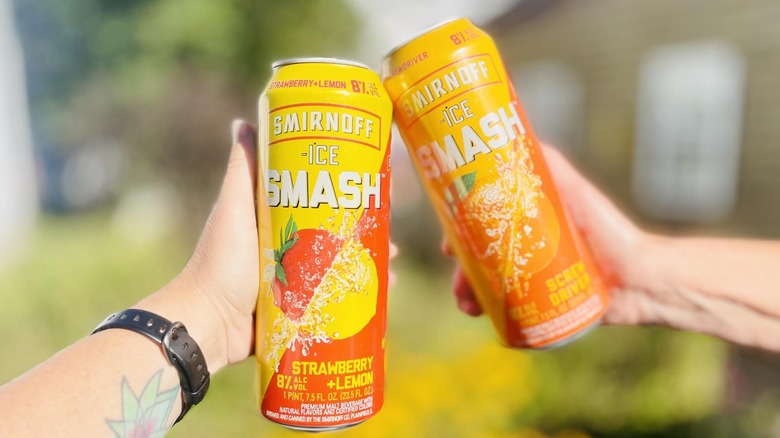 Hands toasting with cans of Smirnoff Ice