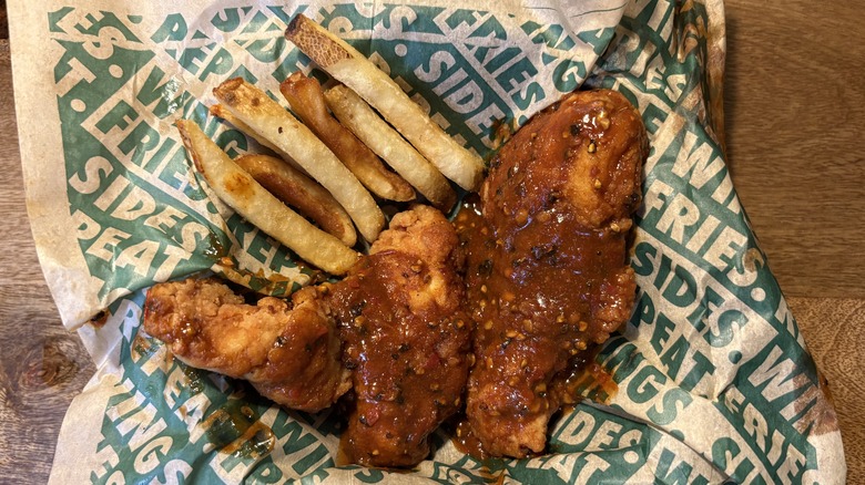 Two Atomic tenders with fries on Wingstop food paper