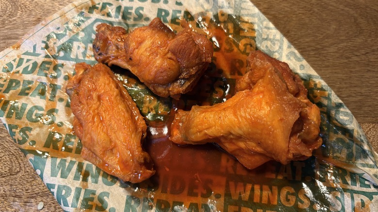Three Hot Lemon bone-in wings on Wingstop food paper