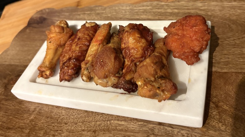 Line of Wingstop chicken wings on white tray