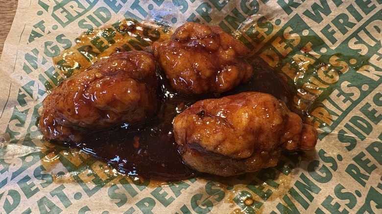 Three Spicy Korean Q boneless wings on Wingstop food paper