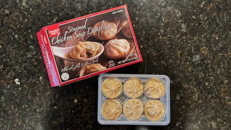 Box and bowl of Trader Joe's Steamed Chicken Soup Dumplings on black counter