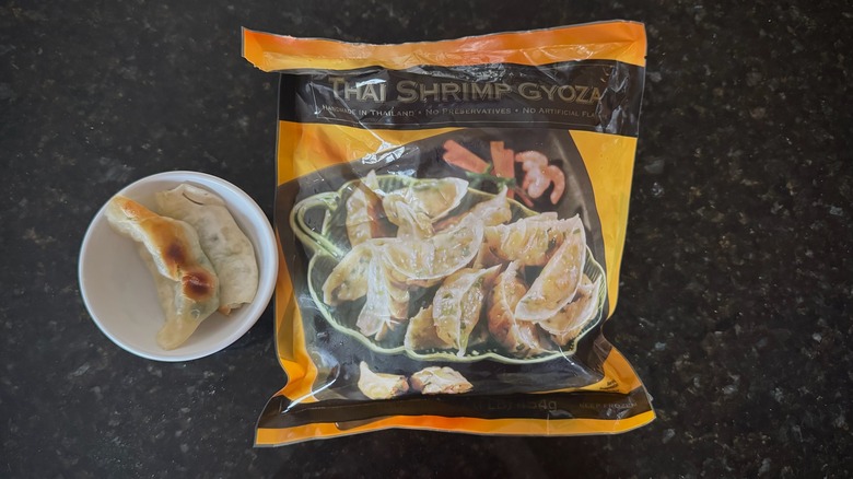 Bag and bowl of Trader Joe's Thai Shrimp Gyoza on black counter