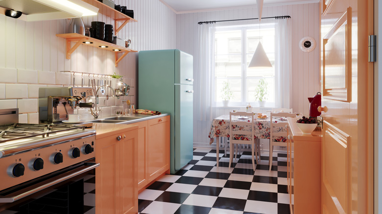 Vintage 1960s style kitchen with pink cabinets and a checkered floor.