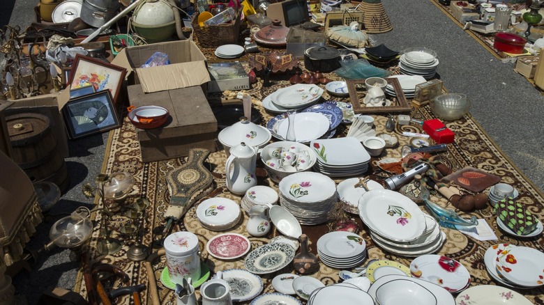 A carpet laid out with a handful of vintage dishes on top of it