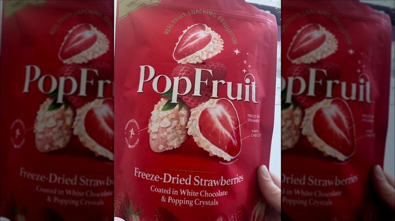 Close-up of someone holding a bag of PopFruit Freeze-Dried Strawberries