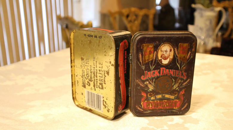 Open antique replica tin bearing the words "Jack Daniel's No. 7 Old-Time Tennessee Whiskey."