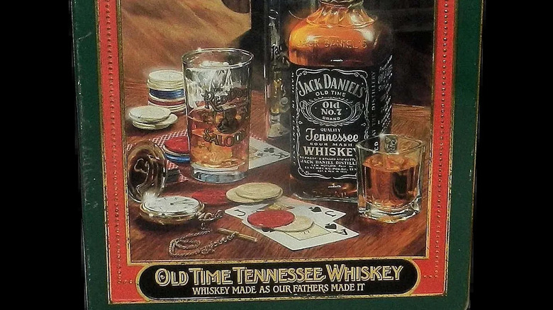 Jack Daniel's tin featuring a bottle of the whiskey on a table next to shot glasses and playing cards.