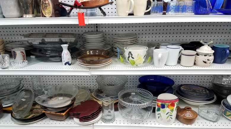 Shelves at a thrift store full of various dinnerware