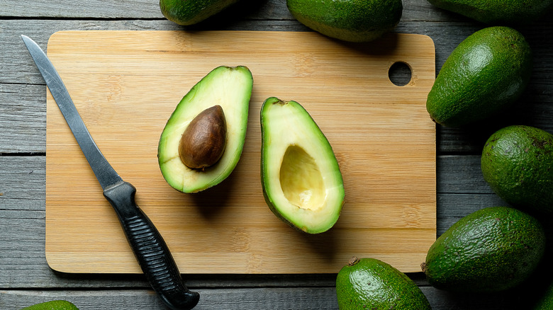 a sliced avocado on a cutting board ready to be sliced