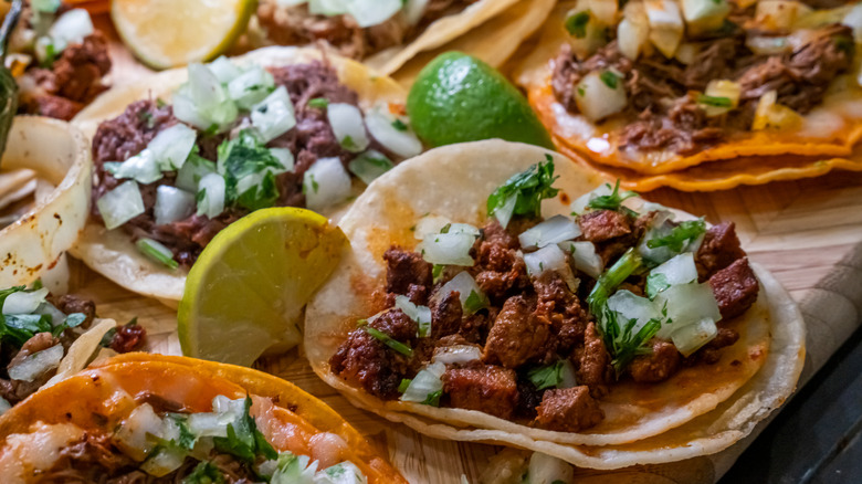 Assortment of tacos on small, flour tortillas.