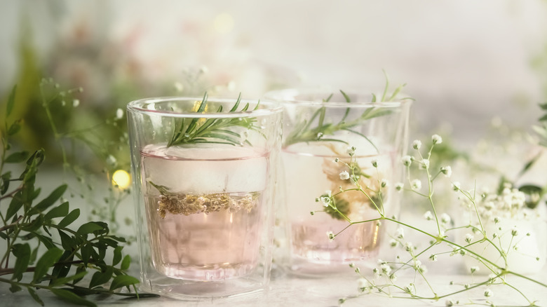 rosemary sprigs adorning light pink cocktails in glasses