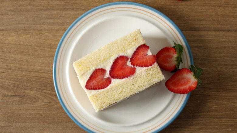 A strawberry fruit sandwich with heart-shaped strawberries on a plate