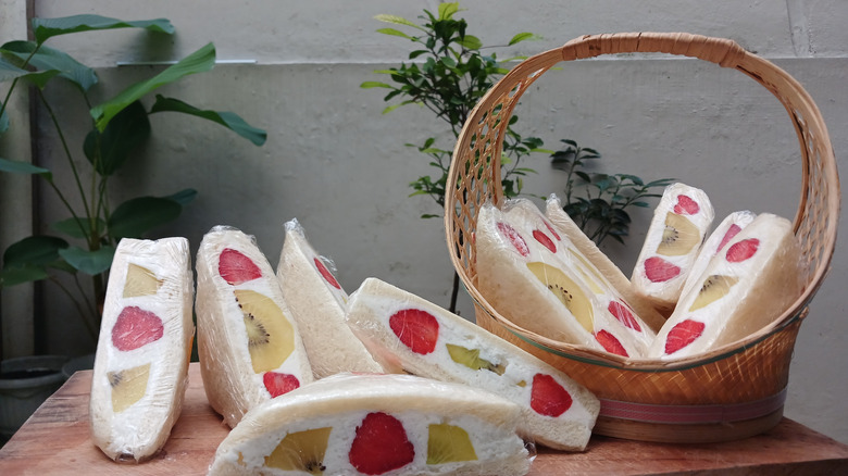 Fruit sandwiches wrapped in plastic wrap in a basket