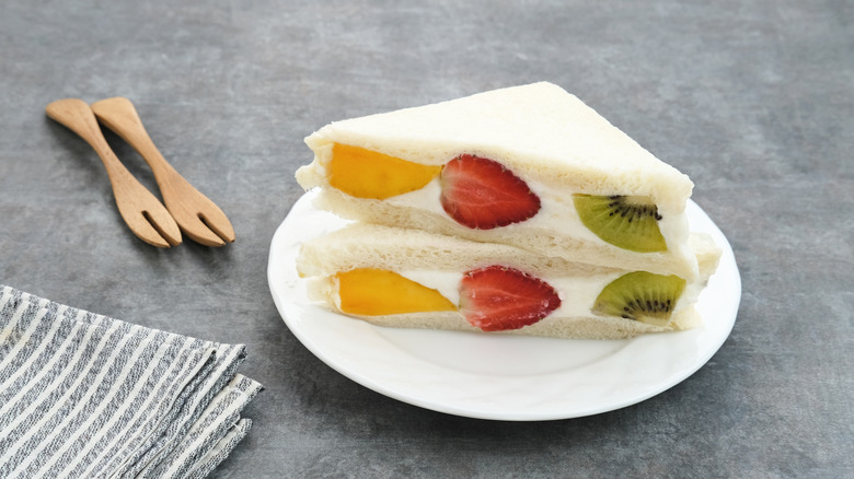 Two fruit sandwich halves with orange, strawberry, and kiwi