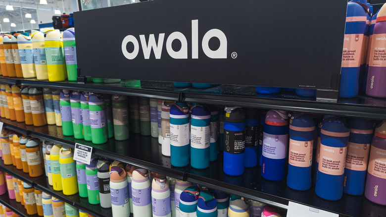 A store shelf stocked with Owala bottles in a variety of colors.