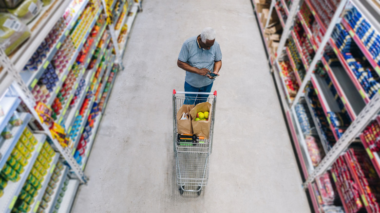 man standing in the middle of a store aisle