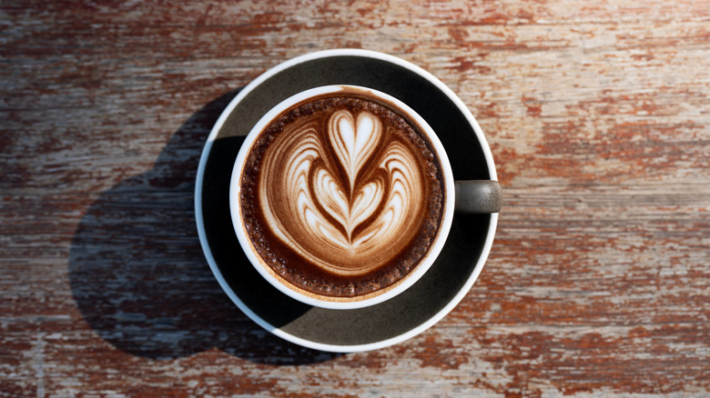 A mocha latte in a cup with a heart design.