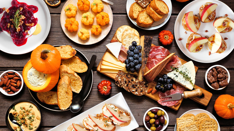 autumn charcuterie board with apples pumpkins, cheese, and crackers