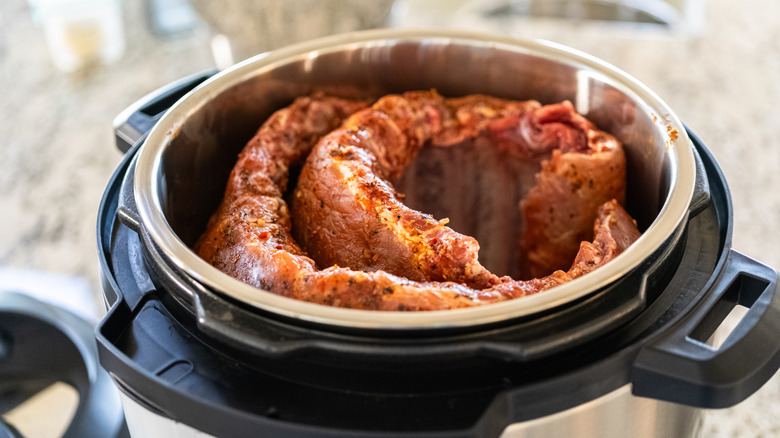 Ribs are arranged in a pressure cooker.